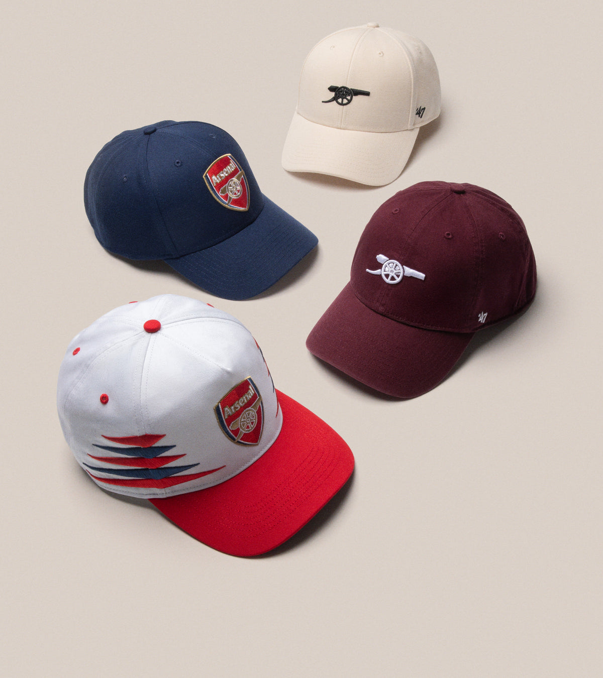 4 Arsenal hats, navy, cream, burgundy and white/red all featuring the arsenal logo or emblem 