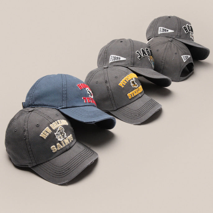 6 grey blue NFl hats of different NFL teams pictured in a line 