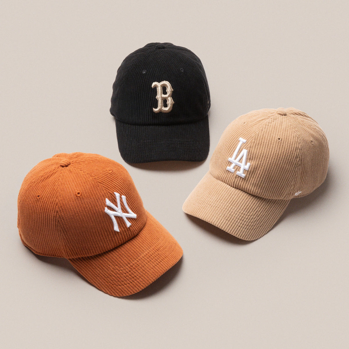 A black Boston Red Sox hat, brown Los Angeles Dodgers hat and orange New York Yankees hat all in corduroy material
